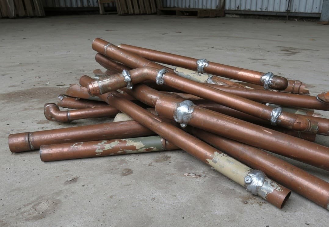Copper pipes with soldered joints and patches of old paint